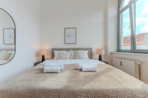 a white bedroom with a large bed with two pillows at Hakuna Cozy-Living city Center - free parking in Graz