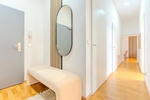 a dressing room with a mirror and a stool at Hakuna Cozy-Living city Center - free parking in Graz +6 photos