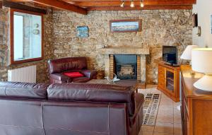 a living room with a leather couch and a fireplace at 4 Bedroom Gorgeous Home In Sibiril in Sibiril