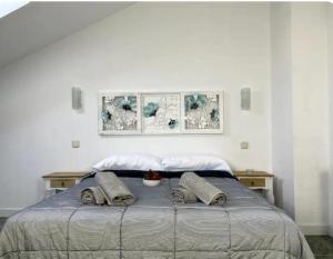 a bedroom with a bed with three pictures on the wall at Great Duplex in Arganda del Rey