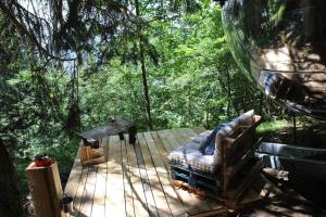 a couch and a table on a deck in the woods at Mirror globe Kandasphere in Saint-Gervais-les-Bains +65 photos