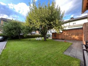 a yard with a tree and white chairs at Appartements Luna by Schladming-Appartements in Schladming +8 photos