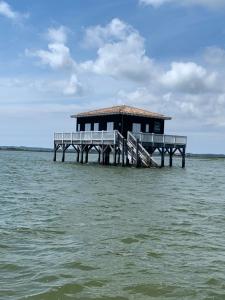 a building on a pier in the water at Relax plage et bassin in Le Porge