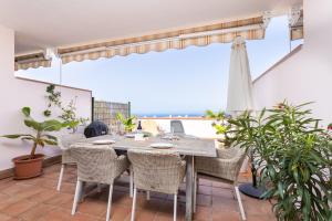 un tavolo e sedie su un patio con vista sull'oceano di Blue Ocean View ad Acantilado de los Gigantes