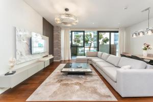 a living room with a white couch and a tv at FAM Living - City Walk - Opulent Living in Dubai