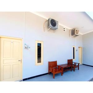 a room with two chairs and a table and a door at Wisma Mekar Jaya near Solo Safari Mitra RedDoorz in Karanganyar