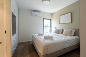 a bedroom with a large bed and a window at Dizengoff Deluxe Retreat in Tel Aviv