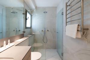 a bathroom with a glass shower and a sink at Dizengoff Deluxe Retreat in Tel Aviv +29 photos