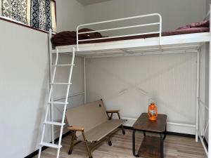 Habitación con litera, silla y mesa. en 球美の駅, en Kumejima