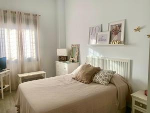 biała sypialnia z łóżkiem i telewizorem w obiekcie Apartamento en el Centro con Parking w mieście Tarifa