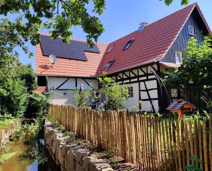 a house with a solar roof and a fence at WOLFSHÖHLE Schwarzwald-Apartment in Achern