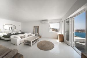 a white living room with a bed and a couch at Villa Joy Mykonos Boutique Hotel in Ano Mera +49 photos