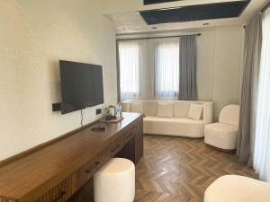 a living room with a couch and a flat screen tv at Now Boutique Hotel in Erdemli