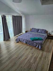 a bedroom with a bed and a wooden floor at Casa Cristian in Limanu