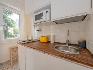 Una cocina con fregadero y encimera de madera. en Milano 2 Pax Wi-Fi- Via D'Agrate, 19 C, en Milán 18 fotos más