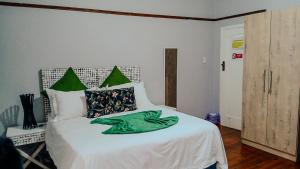 a bedroom with a bed with a green blanket on it at PLANES in Kokstad