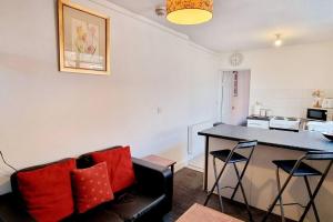 a living room with a couch and a table with red pillows at 1 bedroom flat in thurmaston in Thurcaston