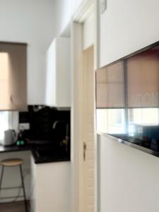 a kitchen with white cabinets and a door to a kitchen at Stylish City Centre Studio - Grand Central House in Gibraltar