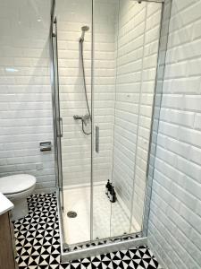 a shower in a bathroom with a black and white floor at Stylish City Centre Studio - Grand Central House in Gibraltar