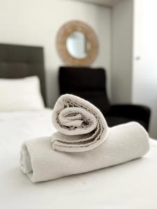 a pile of towels sitting on top of a bed at Stylish City Centre Studio - Grand Central House in Gibraltar