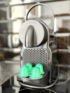 a coffee maker with four green cups in it at Stylish City Centre Studio - Grand Central House in Gibraltar