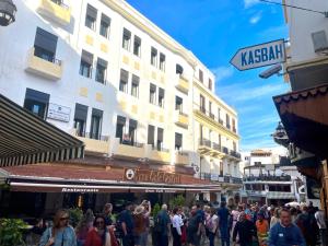 丹吉尔Hotel Mauritania的一群人沿着街道走着,街道上有许多建筑