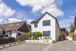 a white house with a black roof at Brighton Seaside Retreat in Falmer