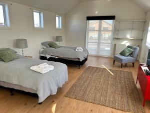 a bedroom with two beds and a chair and a window at Cbay Executive Accommodation in Timaru