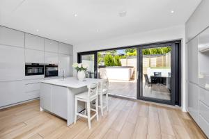 a kitchen with white cabinets and a large window at Brighton Seaside Retreat in Falmer