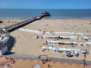 a beach with umbrellas and people on the sand at residentie NAUSICAA in Blankenberge