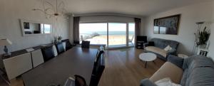 a living room with a table and a view of the beach at residentie NAUSICAA in Blankenberge