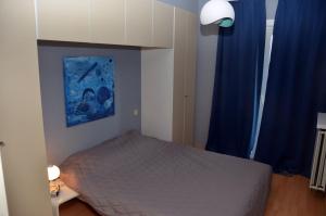 a bedroom with a bed and a blue curtain at residentie NAUSICAA in Blankenberge