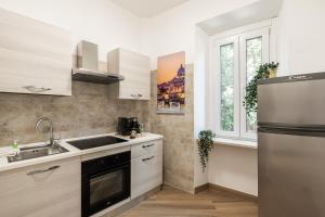 a kitchen with a sink and a refrigerator at Alba Vatican Apartment in Rome +15 photos
