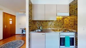 a kitchen with white cabinets and a sink at One-bedroom apartment in a quiet neighborhood in Sierre