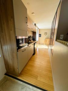 Eine Küche mit weißen Schränken und Holzboden in der Unterkunft Le diX - Classic Room - VallabriX proche UZES in Vallabrix + 4 Fotos