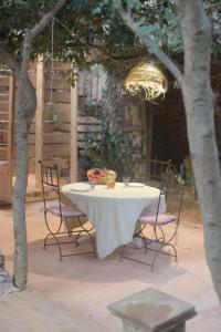 a table with chairs and a bowl of fruit on it at Magnifique eco-gîte des Marronniers avec terrasse in La Roquebrussanne