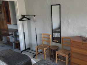 une chambre avec un miroir et deux chaises et un lit dans l'établissement Sherwood Cottage, à Lorraine