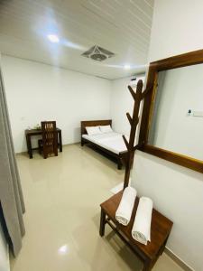 a room with a bed and a table and a mirror at Premium Cottages B&B in Kurunegala +17 photos