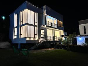 a large house with two chairs in front of it at night at Prayer Mountain Cove in Kampala