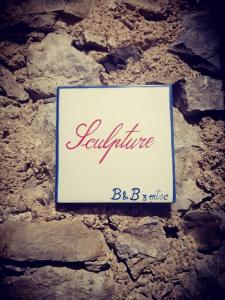 a sign on a stone wall with the word reputation at #3MTSOPRAILCIELO '' SCuLPTuRe '' in Felitto