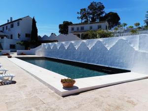 a swimming pool in front of a white fence at Los Alcornoquillos in Carratraca