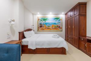 a bedroom with a bed and a painting on the wall at Woody House Saigon Center in Ho Chi Minh City