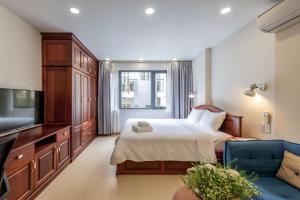a bedroom with a bed and a tv and a couch at Woody House Saigon Center in Ho Chi Minh City