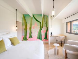 a bedroom with a white bed and a painting on the wall at Maison Nova - Boutique Hôtel & Spa in Collioure