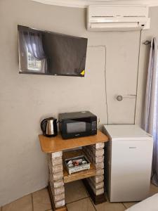 a microwave and a refrigerator in a small room at Sunset View River Guesthouse in Douglas