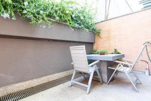 a table and a chair sitting next to a wall at Città Studi Suites - Top Collection in Milan