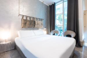 a bedroom with a large white bed and a window at Città Studi Suites - Top Collection in Milan
