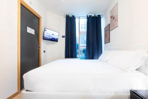 a bedroom with a large white bed and a window at Città Studi Suites - Top Collection in Milan
