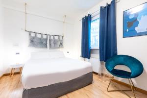 a bedroom with a bed and a blue chair at Città Studi Suites - Top Collection in Milan
