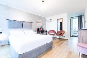 a bedroom with a large white bed and two chairs at Città Studi Suites - Top Collection in Milan